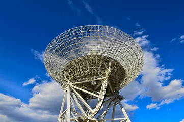 Array of satellite dishes or radio antennas against sky. Space o