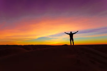 Fototapeten Silhouette of man posing on sand dune during the sunset © Boy