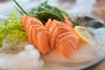 Raw salmon slice or salmon sashimi in Japanese style fresh serve on ice in bowl.