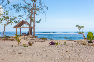 White coral beach on tropica island with stunning blue ocean and nice beach hut
