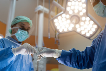 Asian doctor and an assistant in the operating room for surgical venous vascular surgery clinic in...