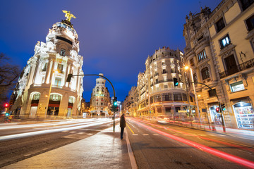 Fototapeta na wymiar Car and traffic lights on Gran via street, main shopping street in Madrid at night. Spain, Europe. Lanmark in Madrid, Spain