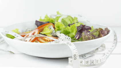 Healthy salad diet food concept, props decoration tomatoes, apple, avocado, Red chilli, Green pepper , lemon and measuring tape.