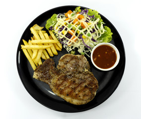 Steak Kurobuta pork chop black pepper sauce in plate on white background. props decoration French fries, green salad, Top view with copy space for your text..