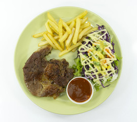 Steak Kurobuta pork chop black pepper sauce in plate on white background. props decoration French fries, green salad,Top view.