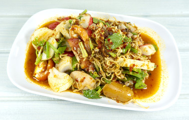 Instant noodle spicy salad in white plate Thai foods. white wooden backdrop.Top view. Copy Space.
