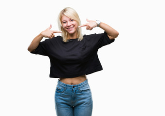 Young beautiful blonde woman over isolated background smiling confident showing and pointing with fingers teeth and mouth. Health concept.