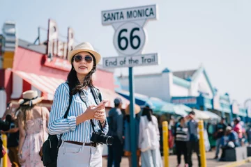 Poster tourist standing next to the sign of Santa Monica © PR Image Factory
