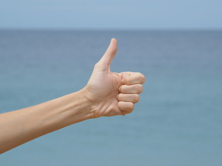 hand with thumb up on blue sky