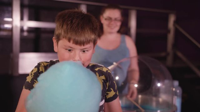 Young Boy Happily Eats Candy Floss and Smiles