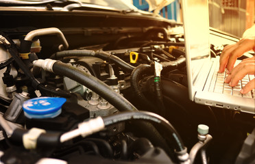 Mechanic using Laptop Diagnostic machine tools for car.