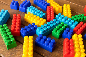 Colorful children's plastic constructor on a wooden table. Conceptual approach to the development of creativity in children