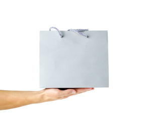 Hand holding beautiful gift gray bag. Close up. Isolated on white background