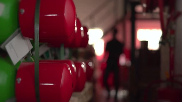 Industrial gas cylinder warehouse is inspected by employee.
