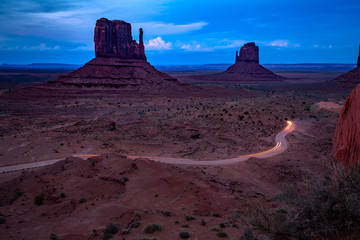 Vehicles exit Monument Valley after a sunset excursion in the Park. Monument Valley of northeast Arizona.