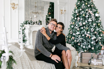 young couple. Happy family having fun at home. Christmas morning in bright living room. Happy new year. decorated Christmas tree
