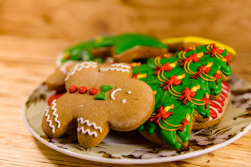 Plate with different christmas gingerbread cookies on wooden table