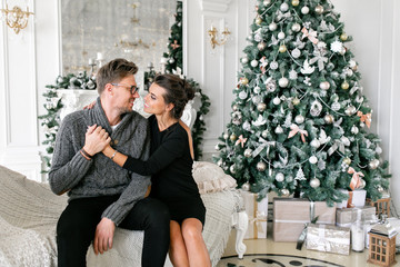 young couple. Happy family having fun at home. Christmas morning in bright living room. Happy new year. decorated Christmas tree