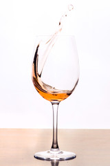 White wine splashes in wine glass