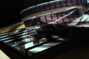 Movie clapper and film reel on a background