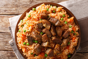 Mexican cuisine: spicy rice cooked with vegetables with tomato sauce and roasted pork close-up. Horizontal top view