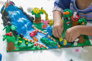 Obraz na płótnie Canvas Child playing with clay molding shapes,Children creativity.