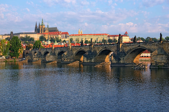 Scenic view on Vltava River and Charles bridge. Prague Castle with ancient Saint Vitus Cathedral at the background. Summer morning landscape photo. Prague, Czech Republic