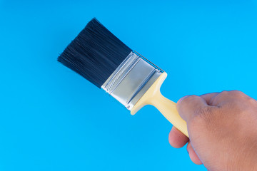 Paint brush on blue colour background with selective focus and crop fragment. Copy space conceptual