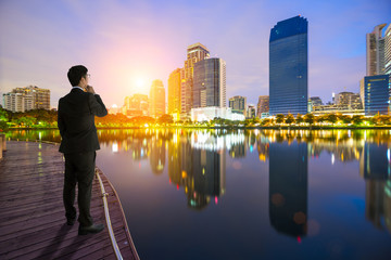 Fototapeta na wymiar businessman looking at the city on sunrise