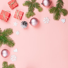 Christmas background with fir branches, lights, red giftboxes, pink decorations, hot drink with marshmallows on pink