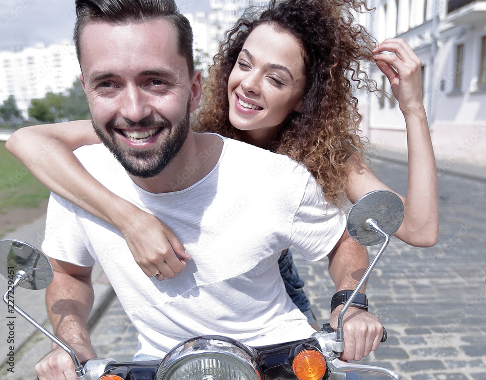 Canvas Prints Happy cheerful couple riding vintage scooter outdoors.