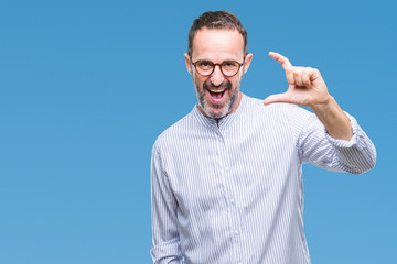 Middle age hoary senior man wearing glasses over isolated background smiling and confident gesturing with hand doing size sign with fingers while looking and the camera. Measure concept.