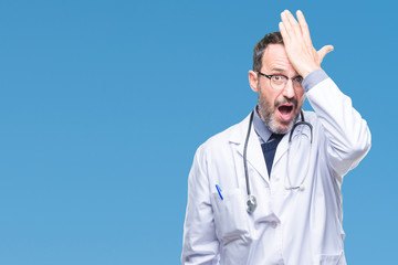 Middle age senior hoary doctor man wearing medical uniform isolated background surprised with hand on head for mistake, remember error. Forgot, bad memory concept.