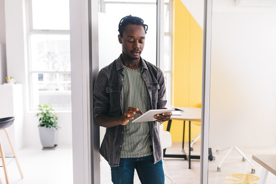 afro-american man standing in flat with tablet