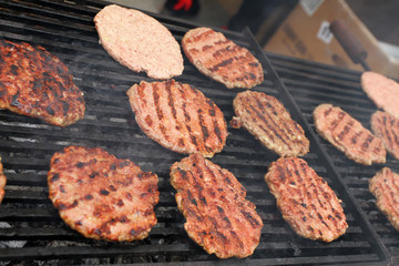 Burger Grilling on Fire. Homemade Hamburgers. Grill Meatballs. Making Hamburgers on a Grill Outdoor. Barbecue Grill Party. Meat Over Coals on Barbecue