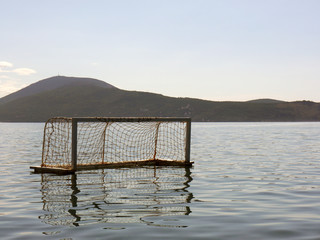 Water polo metal goal on sea with mountains background