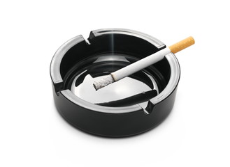 Lit cigarette in black ashtray isolated on white background