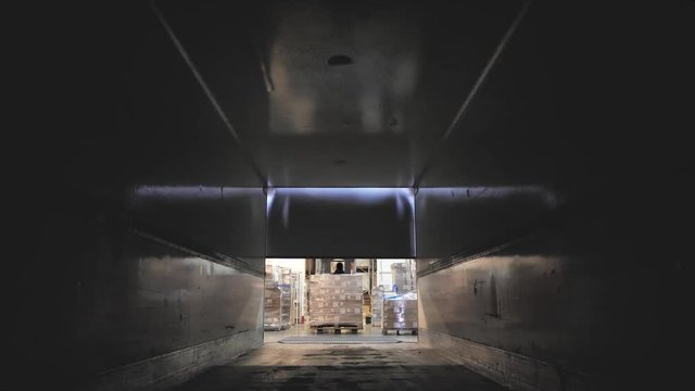 Forklift load boxes from dock into a truck. Logistics and cargo transportation.