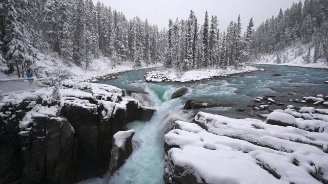 4k Sunwapta Falls and Sunwapta river on the icefield parkway which is a famous and wonderful tourist route across the Canadian rockies and the water colour is unbelievably ice blue with snow contrast