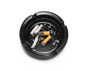 Lit cigarette in black ashtray isolated on white background