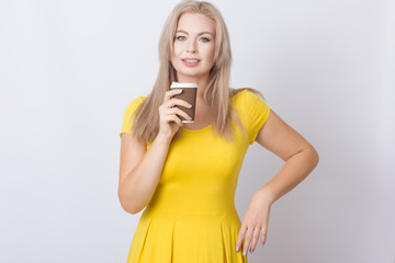 Blonde woman holding coffee cup in her hands