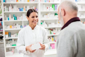 Wall murals Pharmacy Medicine, pharmaceutics, health care and people concept - Happy female pharmacist giving medications to senior male customer
