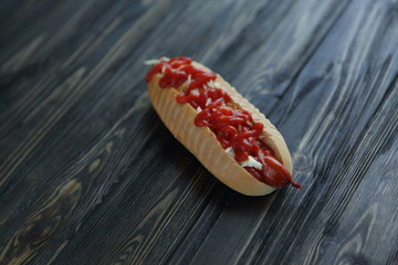 hot dog with spicy sauce on dark background.photo with copy spac