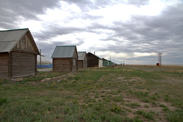 Wooden houses in the steppe of Kazakhstan on a cloudy day