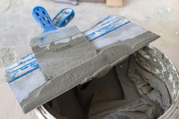 spatula with bucket of glue,ready-made solution of glue in a bucket with a spatula for the work of the mason