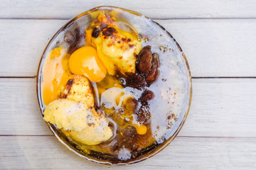 An Asean teen boy pouring egg into the bowl for making famous amous. Food and cooking concept.