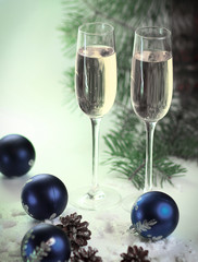 two glasses with champagne and Christmas balls on blue Christmas