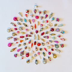 Many colorful new year toys lying on white background in shape of Christmas bauble, top view, flat lay. Creative composition, winter holiday concept, greeting card, square