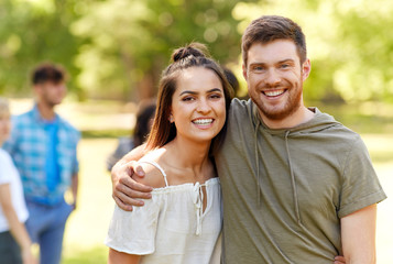 Obraz premium people and relationships concept - happy couple hugging at summer park