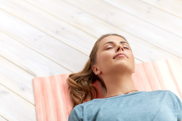 fitness, sport and healthy lifestyle concept - woman doing yoga corpse pose at studio